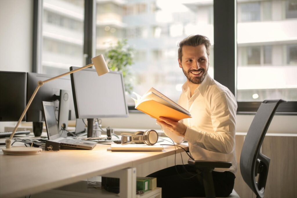 Investor who is satisfied with the tax exclusions on their Qualified Small Business Stock sitting at a modern and high tech desk.